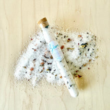Load image into Gallery viewer, Small glass tube with cork lid on a bed of salt and small stones on a light wooden surface.