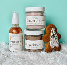 Load image into Gallery viewer, Gingerbread-themed body care products including a spray bottle, jar, and cookie on a textured surface with a light blue background.