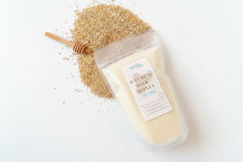 Load image into Gallery viewer, Bag of oatmeal and honey bath salt soak with a honey dipper on a wooden surface